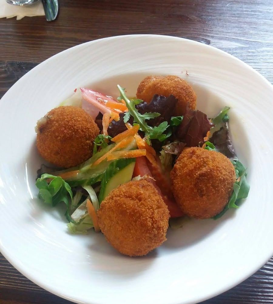 Golden croquetas on a bed of salad